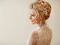 Eleganckie fryzury ślubne z welonem, zdobione perłami i kryształami, podkreślają urodę panny młodej.