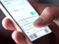 Palec pisze na smartfonie "Już jestem", potwierdzenie przybycia na wesele sms.