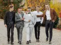 Pięciu panów w eleganckich garniturach, idealny dress code na wesele.
