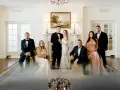Rodzina w eleganckich strojach pozuje do zdjęcia. Panna młoda w białej sukni i pan młody w smokingu, obok nich świadkowie. Zastanawiasz się, jakie dokumenty do ślubu kościelnego są potrzebne?