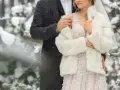 Para młoda w zimowej scenerii. Delikatny śnieg otula ich w dniu ślubu w grudniu.
