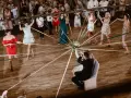 Panny młode i pan młody trzymają wstążki przywiązane do bukietu. Zabawa weselna, przyśpiewki na oczepiny.