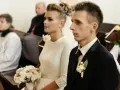 Para młoda w kościele, ona z bukietem, on w garniturze. Ceremonia ślubna, choć w żałobie, odbywa się z godnością.