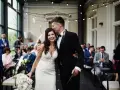 Szczęśliwa para młoda podczas ceremonii ślubnej. Pan całuje pannę młodą w czoło, a ona trzyma bukiet.