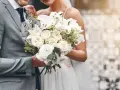Para ślubna trzyma bukiet białych róż i lilii. Czy trzeba mieć bukiet na ślub cywilny? To zależy od Waszych preferencji!