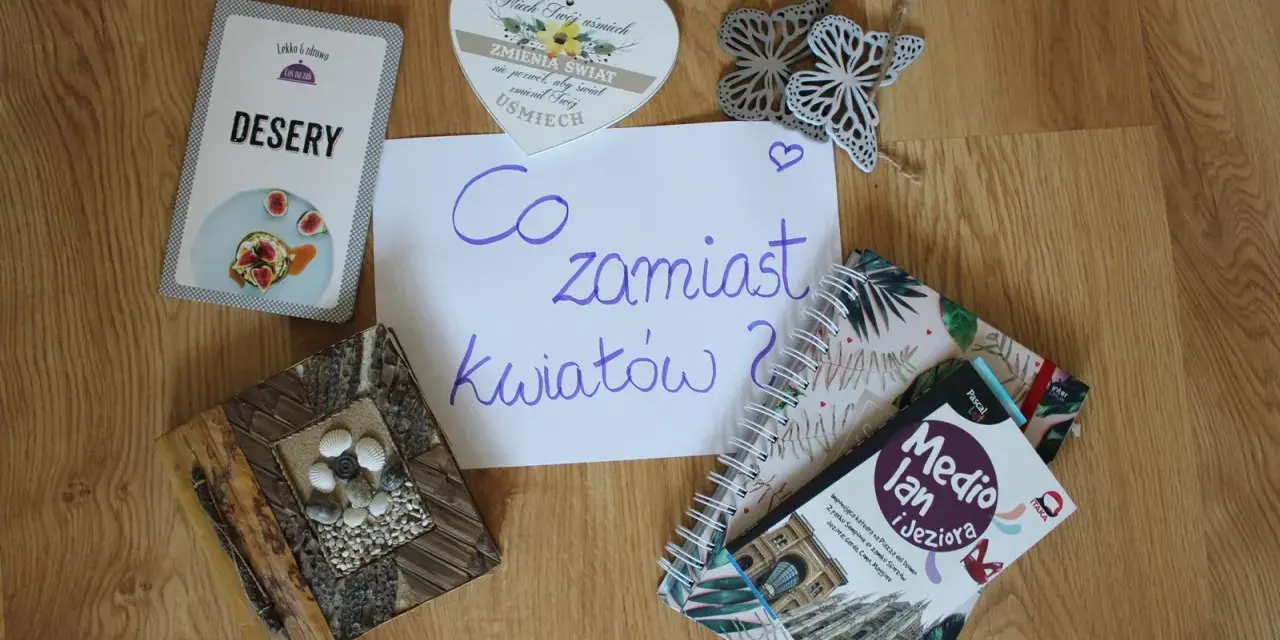 Co zamiast kwiatów na wesele? Na stole leżą karty z deserami, książki o podróżach i serce z napisem "Niech Twój uśmiech zmienia świat".