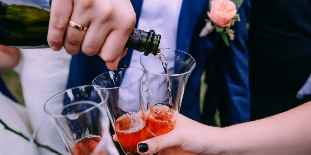 Wesele w pełni! Nalewanie szampana do kieliszków. Ile alkoholu na wesele? Zależy od gości i długości zabawy.