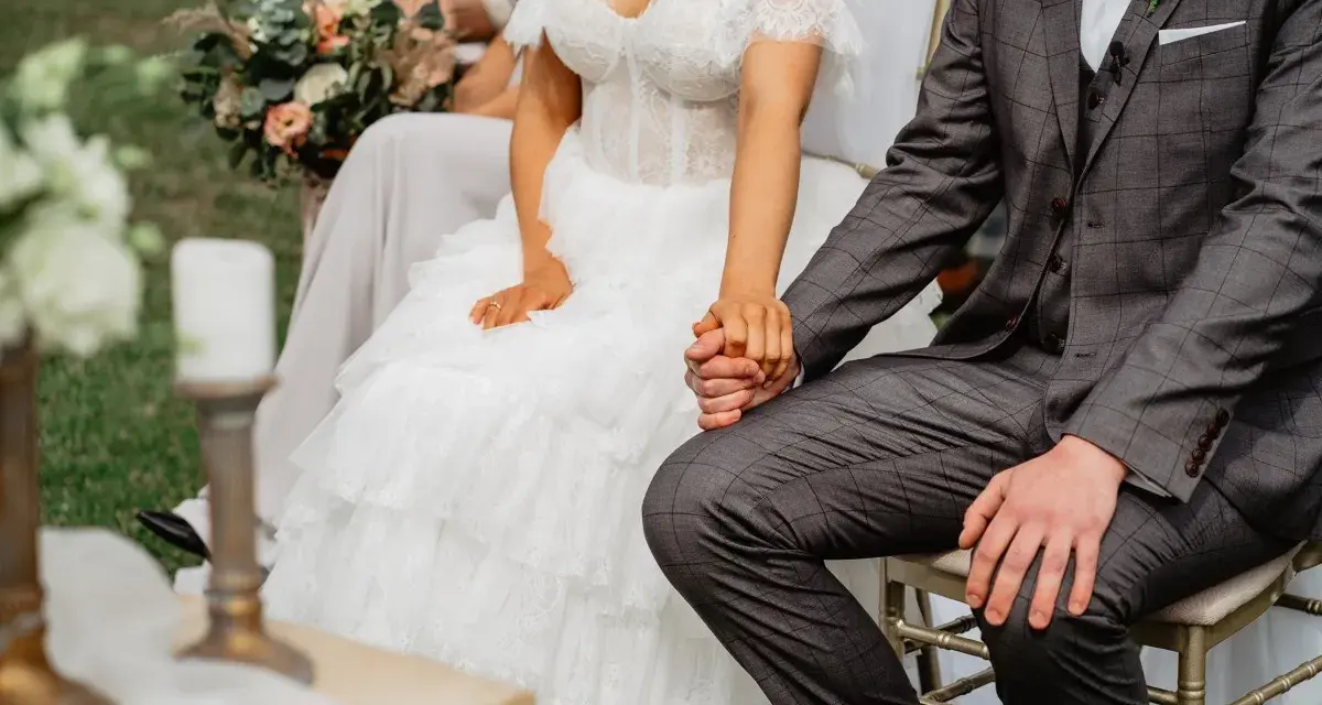 Para młoda trzyma się za ręce. Ślub kościelny to początek wspólnej drogi, pełnej miłości i błogosławieństwa.