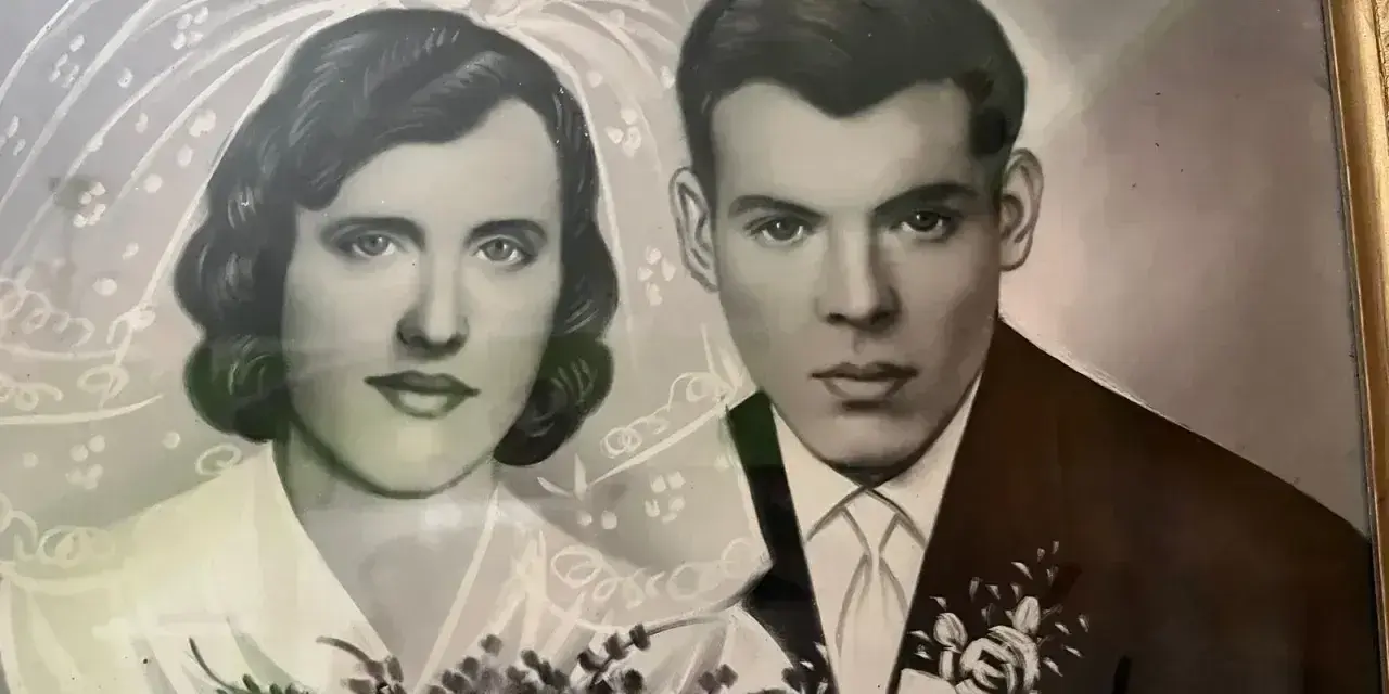 Portret pary młodej, panny młodej w welonie i pana młodego w garniturze. Bukiet róż. Pamiątka z okazji 19 rocznicy ślubu.