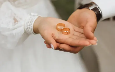 Dłonie pary trzymają obrączki. Czy małżeństwo zawarte za granicą jest ważne w Polsce? To pytanie, które zadaje sobie wiele par.
