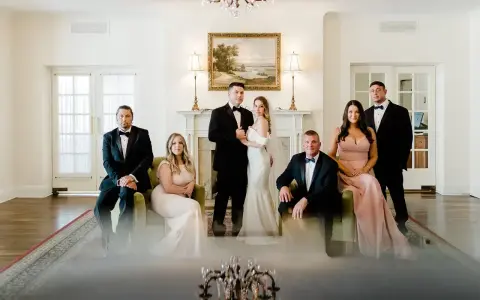 Rodzina w eleganckich strojach pozuje do zdjęcia. Panna młoda w białej sukni i pan młody w smokingu, obok nich świadkowie. Zastanawiasz się, jakie dokumenty do ślubu kościelnego są potrzebne?