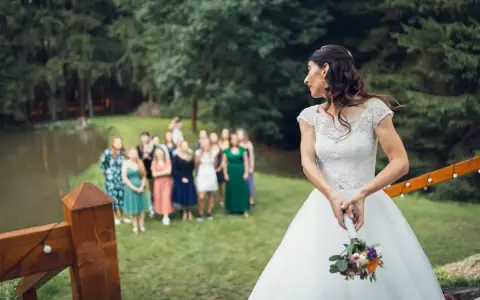 Panna młoda z bukietem ślubnym odwraca się do swoich druhen.