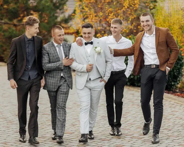 Pięciu panów w eleganckich garniturach, idealny dress code na wesele.