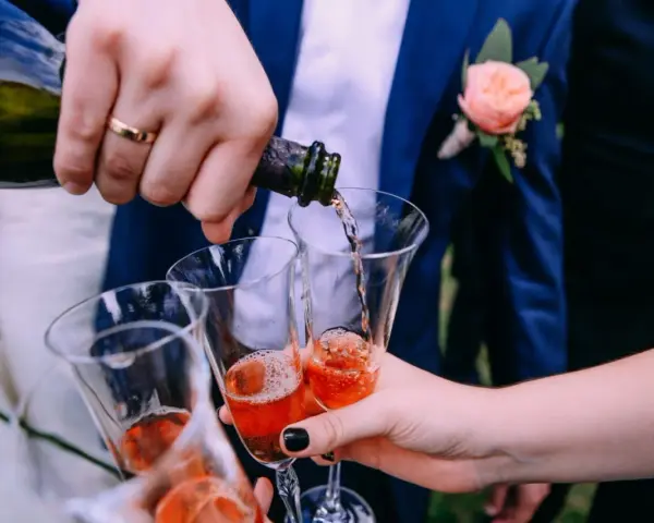 Wesele w pełni! Nalewanie szampana do kieliszków. Ile alkoholu na wesele? Zależy od gości i długości zabawy.
