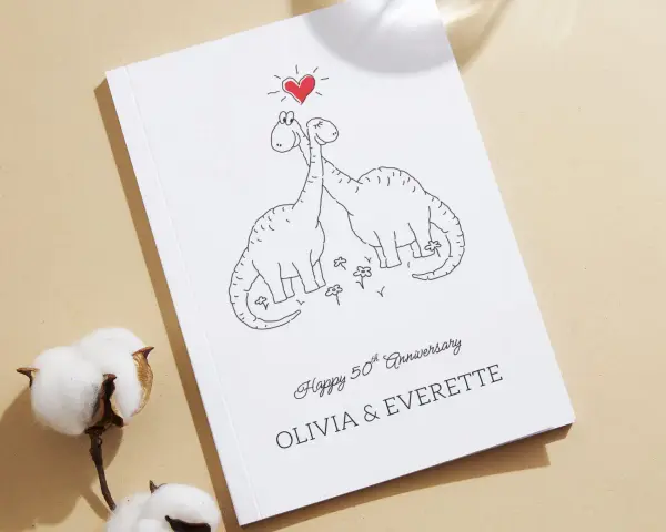 Urocza okładka z dinozaurami i sercem, idealna na odnowienie przysięgi małżeńskiej tekst na wesoło. Olivia i Everette świętują 50 lat razem!