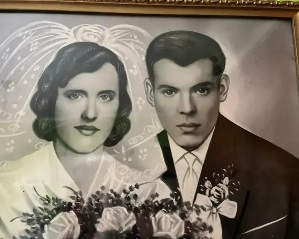 Portret pary młodej, panny młodej w welonie i pana młodego w garniturze. Bukiet róż. Pamiątka z okazji 19 rocznicy ślubu.