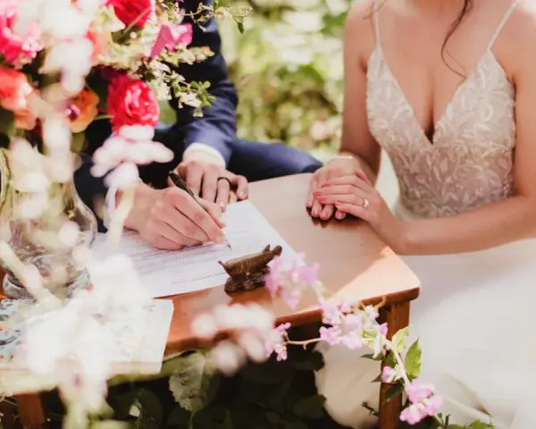 Para młoda podpisuje dokumenty. Czy mąż może przyjąć nazwisko żony? To pytanie, na które odpowiedź znajdziemy w przepisach.