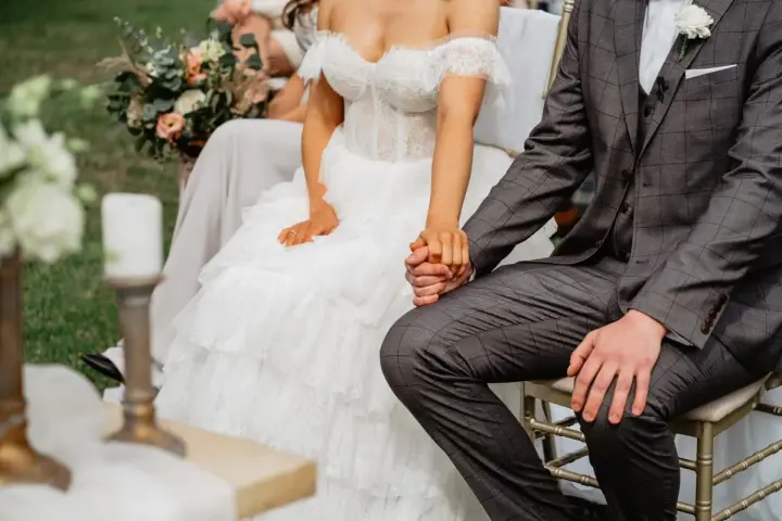 Para młoda trzyma się za ręce. Ślub kościelny to początek wspólnej drogi, pełnej miłości i błogosławieństwa.