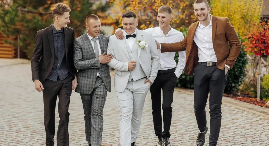Pięciu panów w eleganckich garniturach, idealny dress code na wesele.