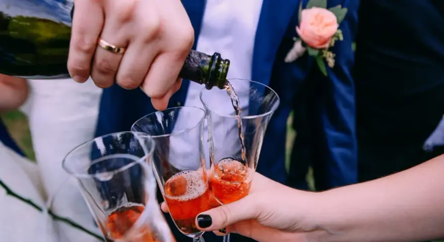 Wesele w pełni! Nalewanie szampana do kieliszków. Ile alkoholu na wesele? Zależy od gości i długości zabawy.