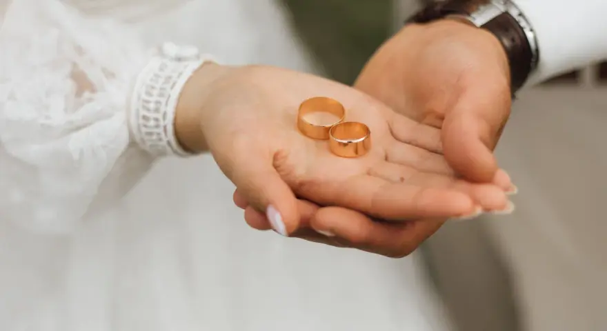 Dłonie pary trzymają obrączki. Czy małżeństwo zawarte za granicą jest ważne w Polsce? To pytanie, które zadaje sobie wiele par.