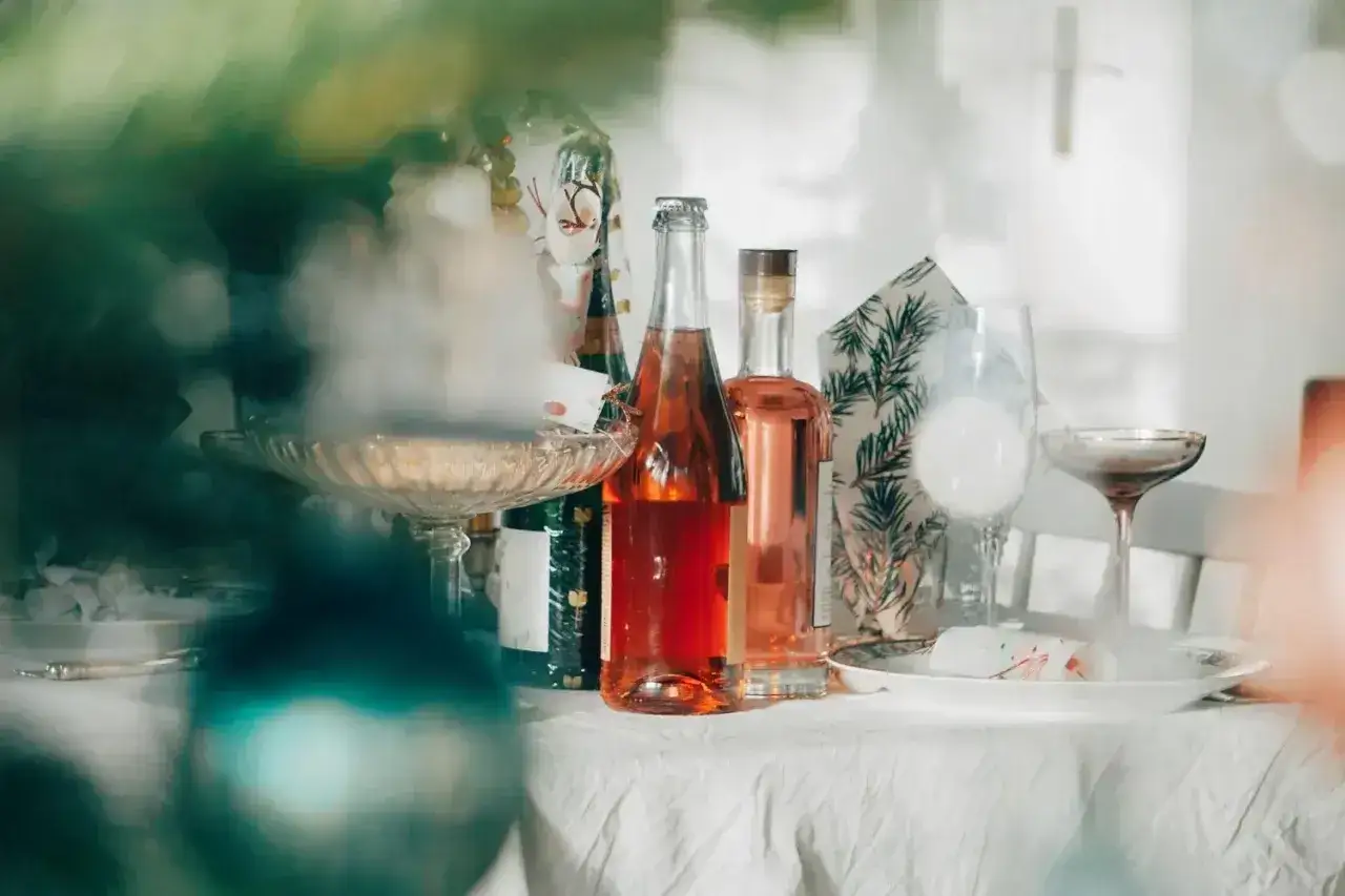 Butelki z r&oacute;żowym winem i kieliszki na stole. Zastanawiasz się, ile alkoholu na wesele?