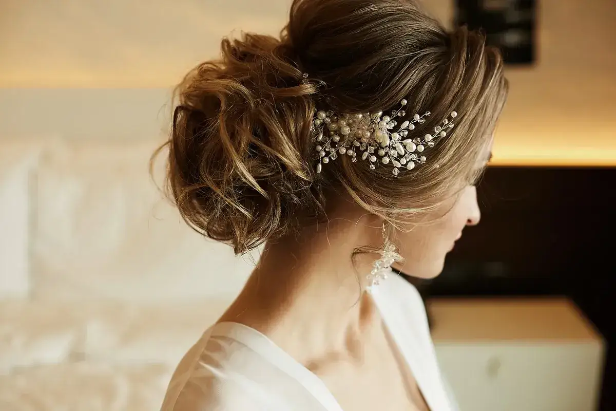 Eleganckie fryzury na wesele dla 40 latki: upięcie z perłami i kryształkami, kt&oacute;re dodaje blasku.